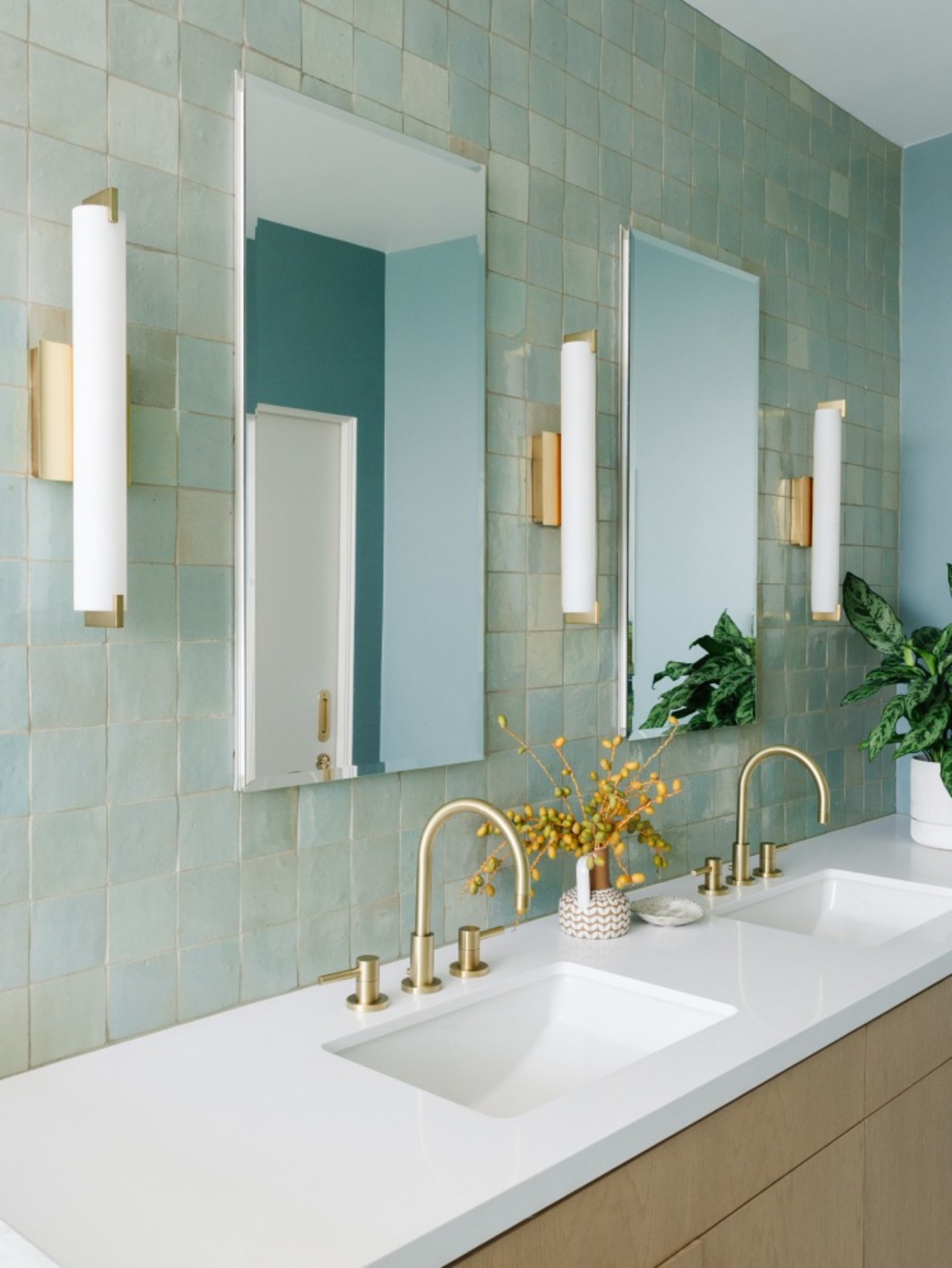 a bathroom with green tile backsplash.