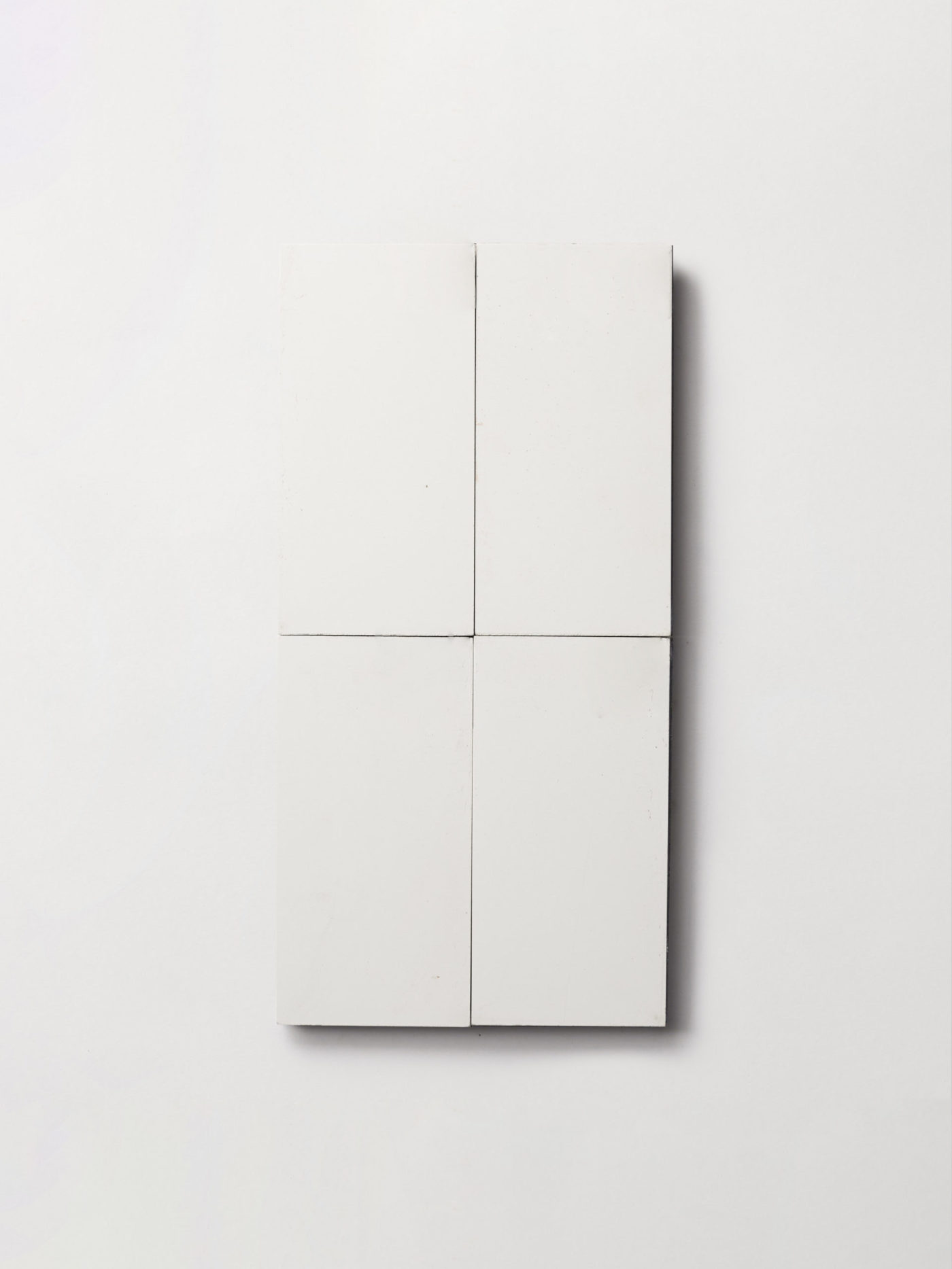 four white rectangle tiles on a white surface.