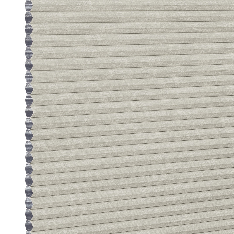 Light beige honeycomb cellular shade with pleated fabric and exposed hexagonal cell ends at left, fully lowered and closed, concealing view; close-up product-style shot on white background with even lighting.