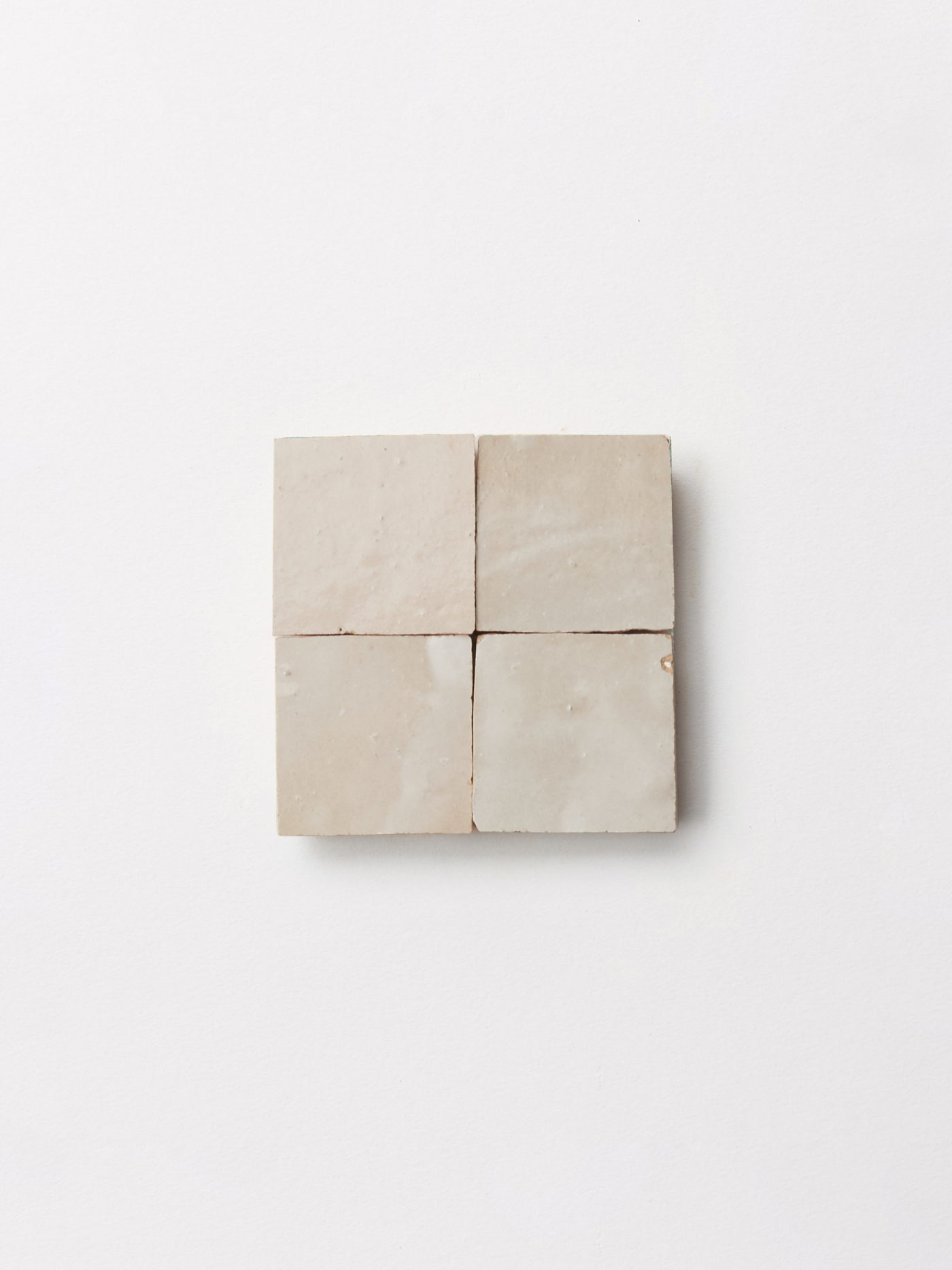 a set of four square tiles on a white surface.