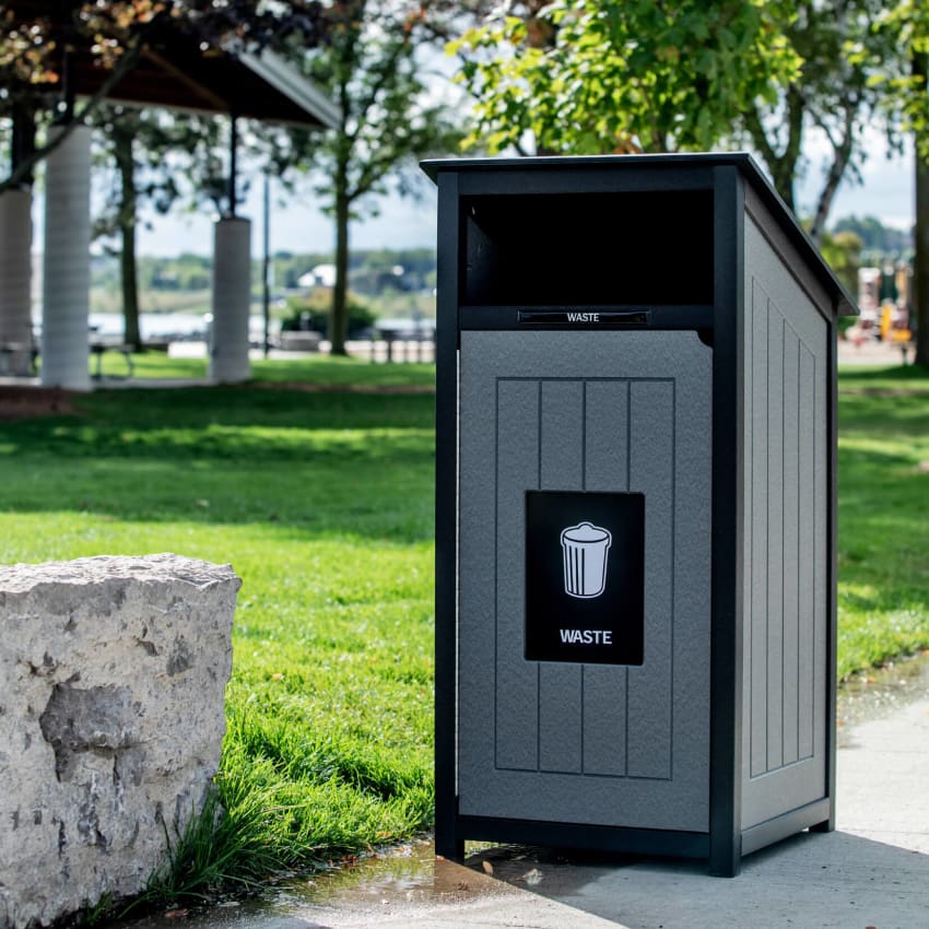 black and grey waste container made from recycled plastic lumber outdoors at a park