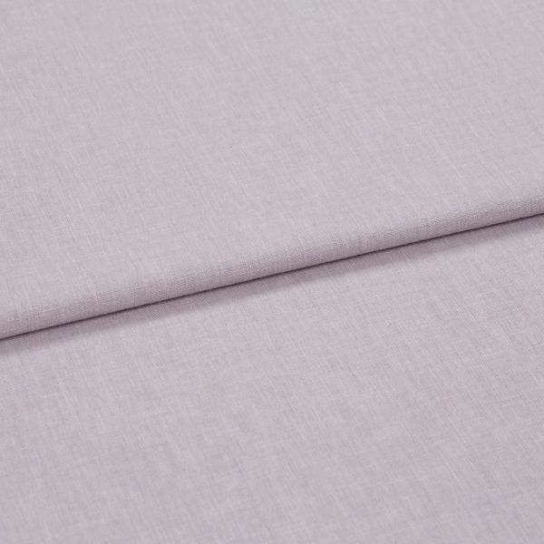 A folded pale lavender woven fabric, folded once to create a horizontal overlap, close-up on a flat surface with soft, diffuse lighting highlighting the subtle weave texture.