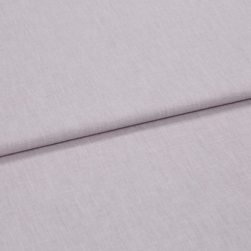 A folded pale lavender woven fabric, folded once to create a horizontal overlap, close-up on a flat surface with soft, diffuse lighting highlighting the subtle weave texture.