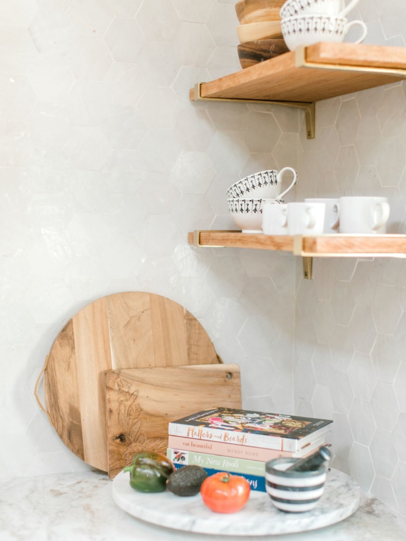 a kitchen counter corner with wooden shelves and a tray of dishes and food.