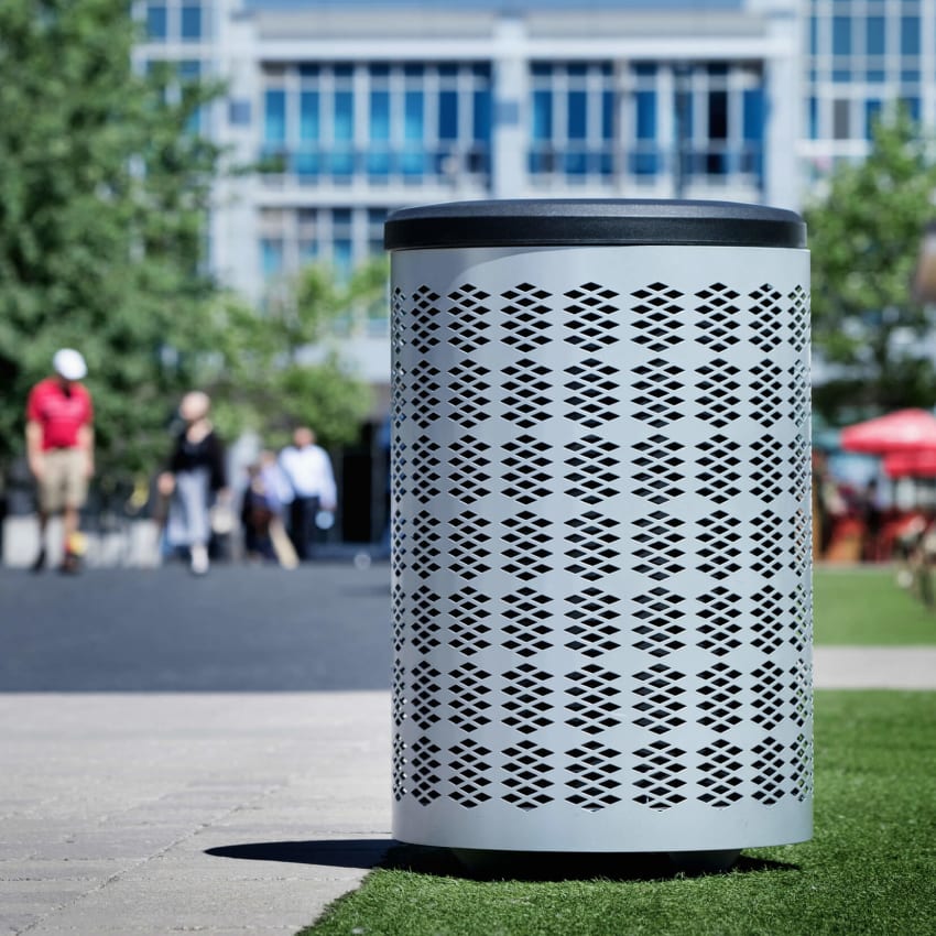 silver metal outdoor waste bin with a durable plastic lid  on a sunny day at a downtown park area