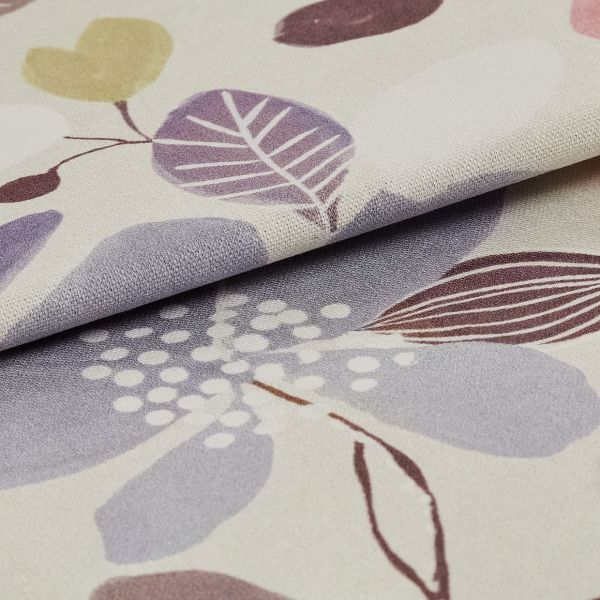 Folded woven fabric sample with pastel leaf-and-dot print â€” layered and overlapping, revealing textured weave â€” close-up macro on a neutral surface, softly lit to emphasize pattern and folds.
