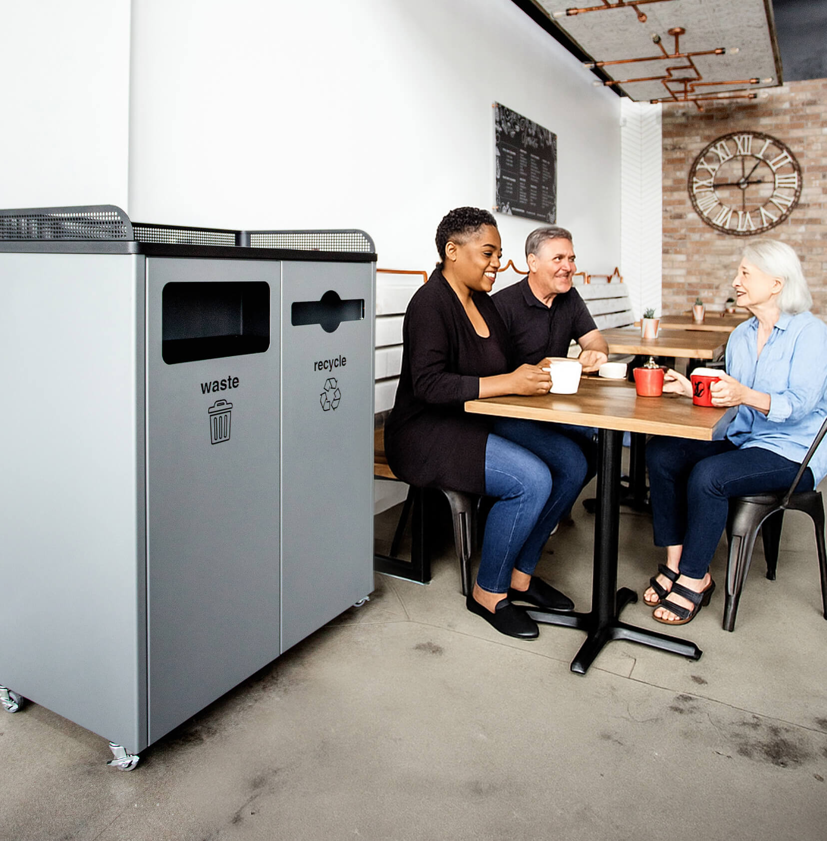 double powder coated steel waste and recycling container in a restaurant with people sitting at tables drinking coffee