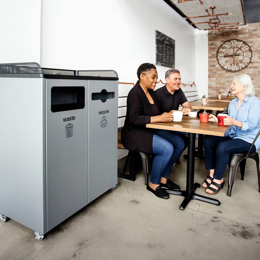 double powder coated steel waste and recycling container in a restaurant with people sitting at tables drinking coffee