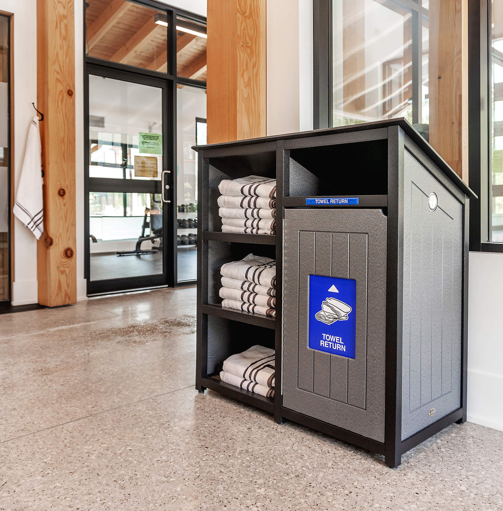 black and grey towel shelf and towel return station indoors at a gym and sauna