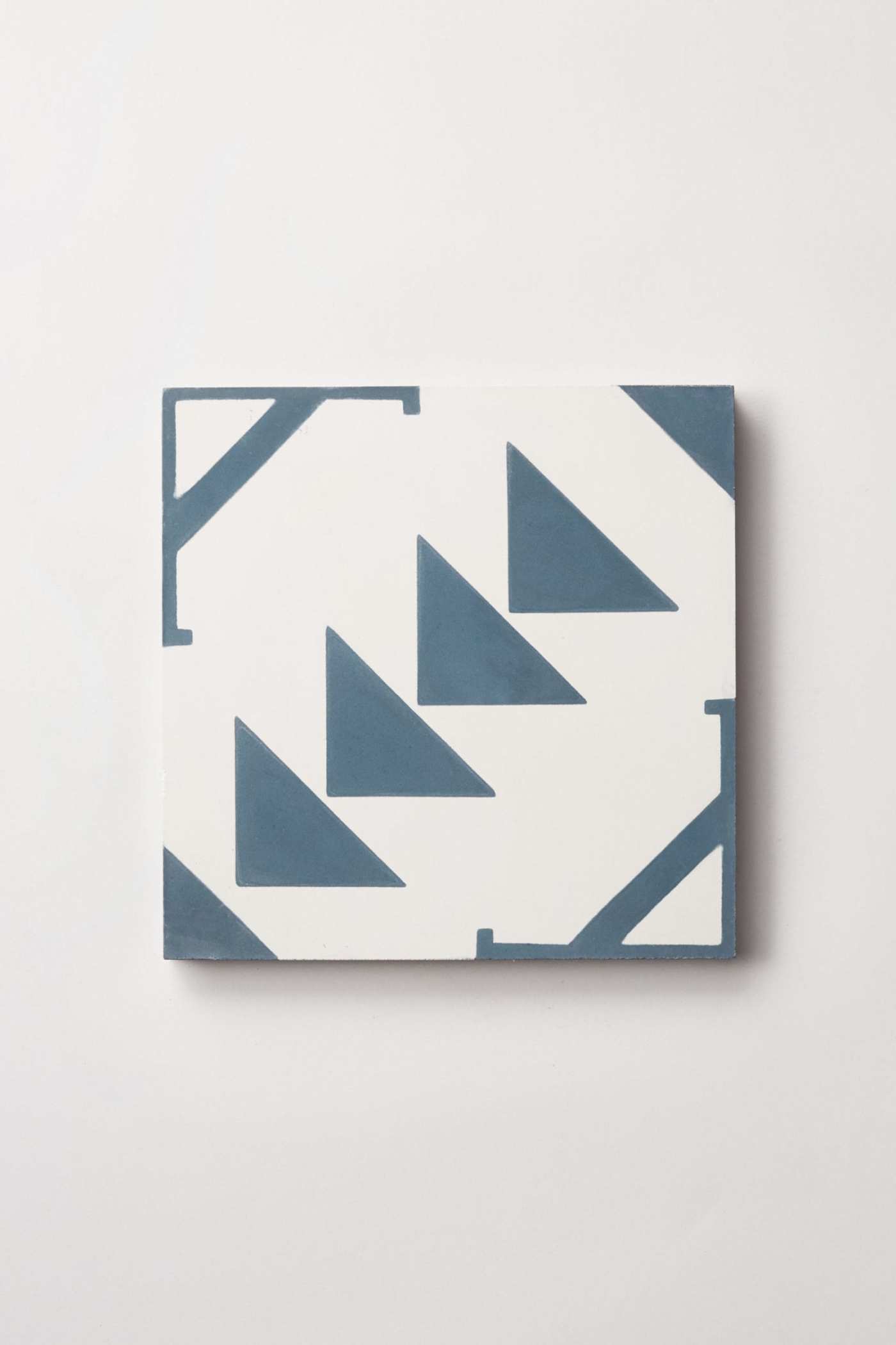 a blue and white tile with triangles on it.