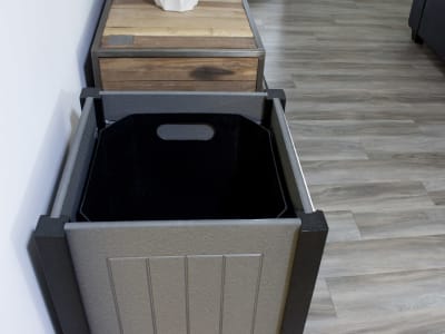 overhead view of waste container with the lid removed showing the plastic liner inside sitting in a modern office