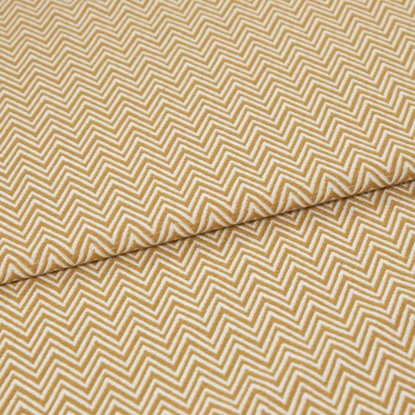 Mustard-and-white chevron fabric, tightly woven, folded across the frame; pattern repeats in narrow zigzags. Close-up view showing textured weave and soft, even lighting on a flat surface.