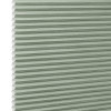 Honeycomb cellular blind with horizontal pleats and white cell edges â€” fully lowered and closed â€” pale sage-green fabric, close-up interior view, evenly lit and diffusing incoming light.