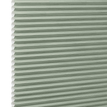Honeycomb cellular blind with horizontal pleats and white cell edges â€” fully lowered and closed â€” pale sage-green fabric, close-up interior view, evenly lit and diffusing incoming light.