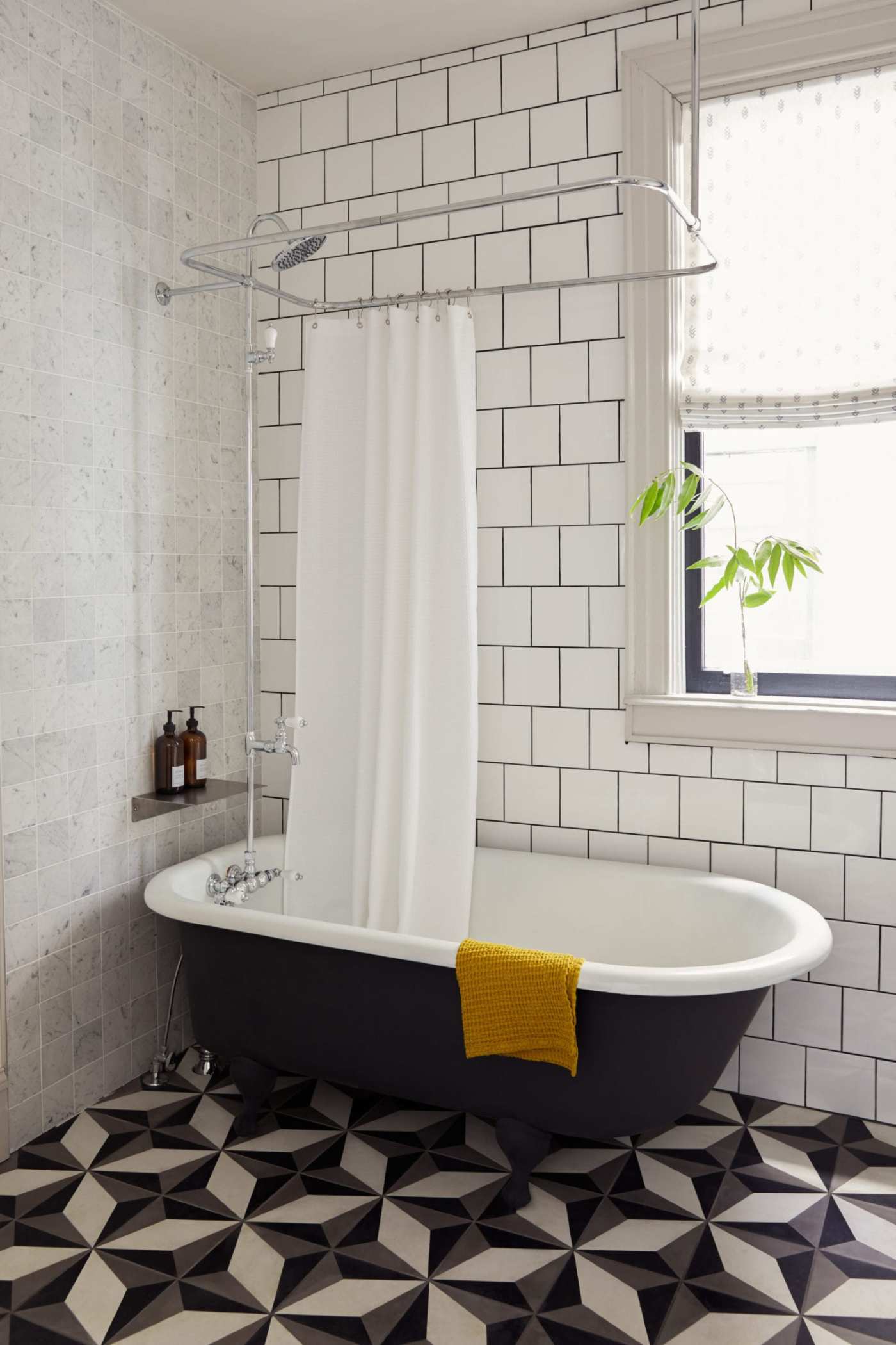 a bathroom with a black and white tiled floor and white walls.