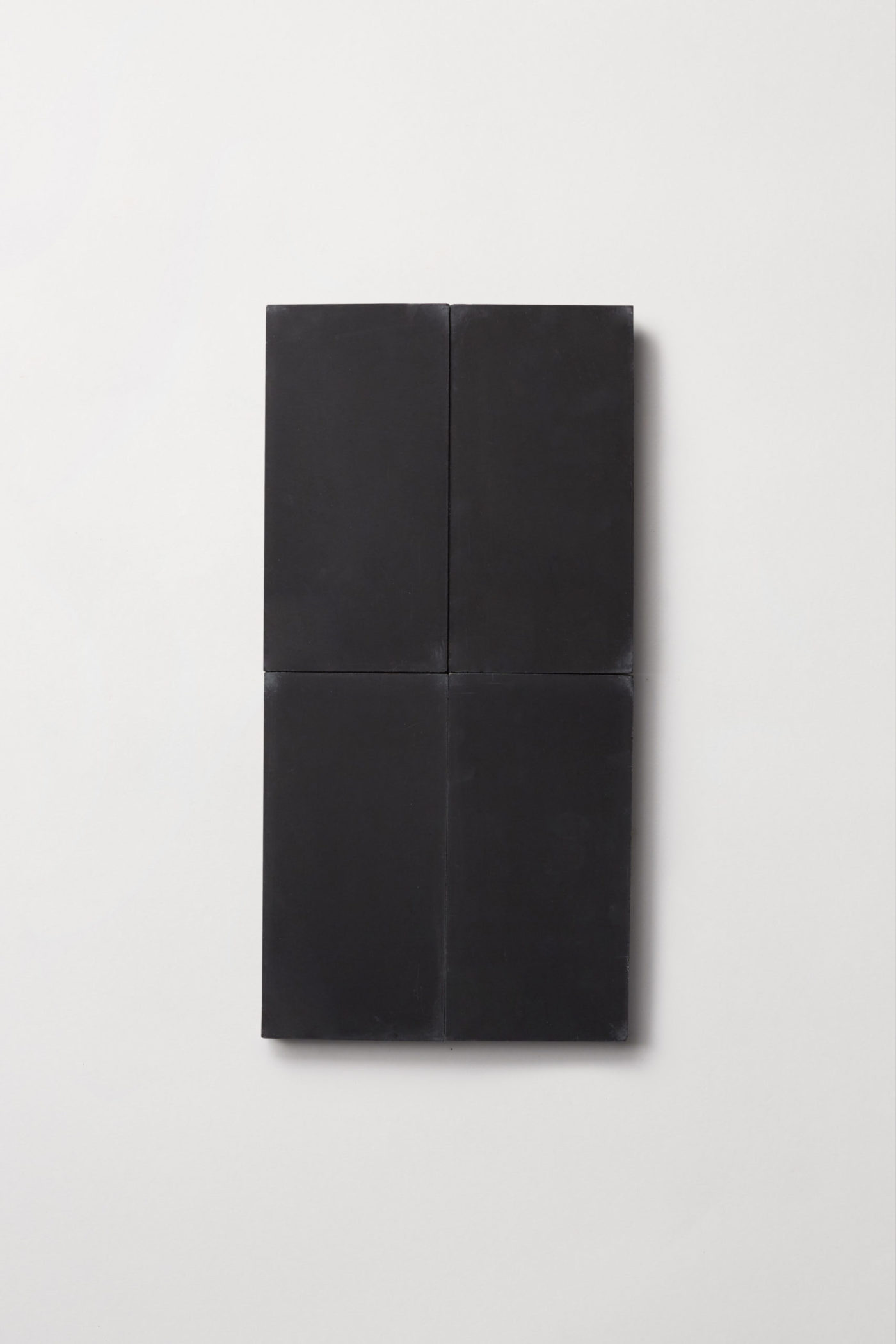 four black rectangle tiles on a white surface.