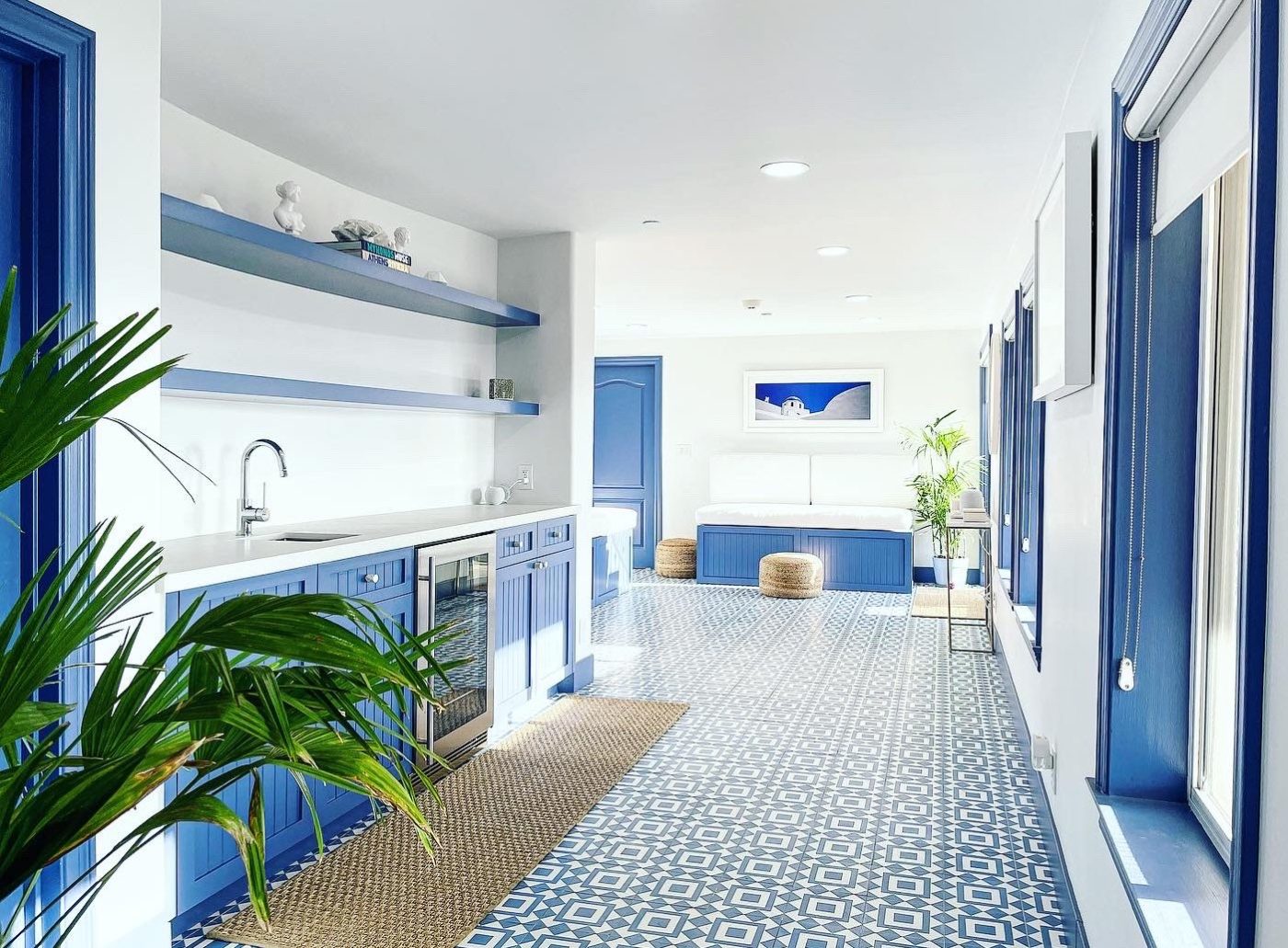 a blue tiled kitchen with cabinets and a potted plant.