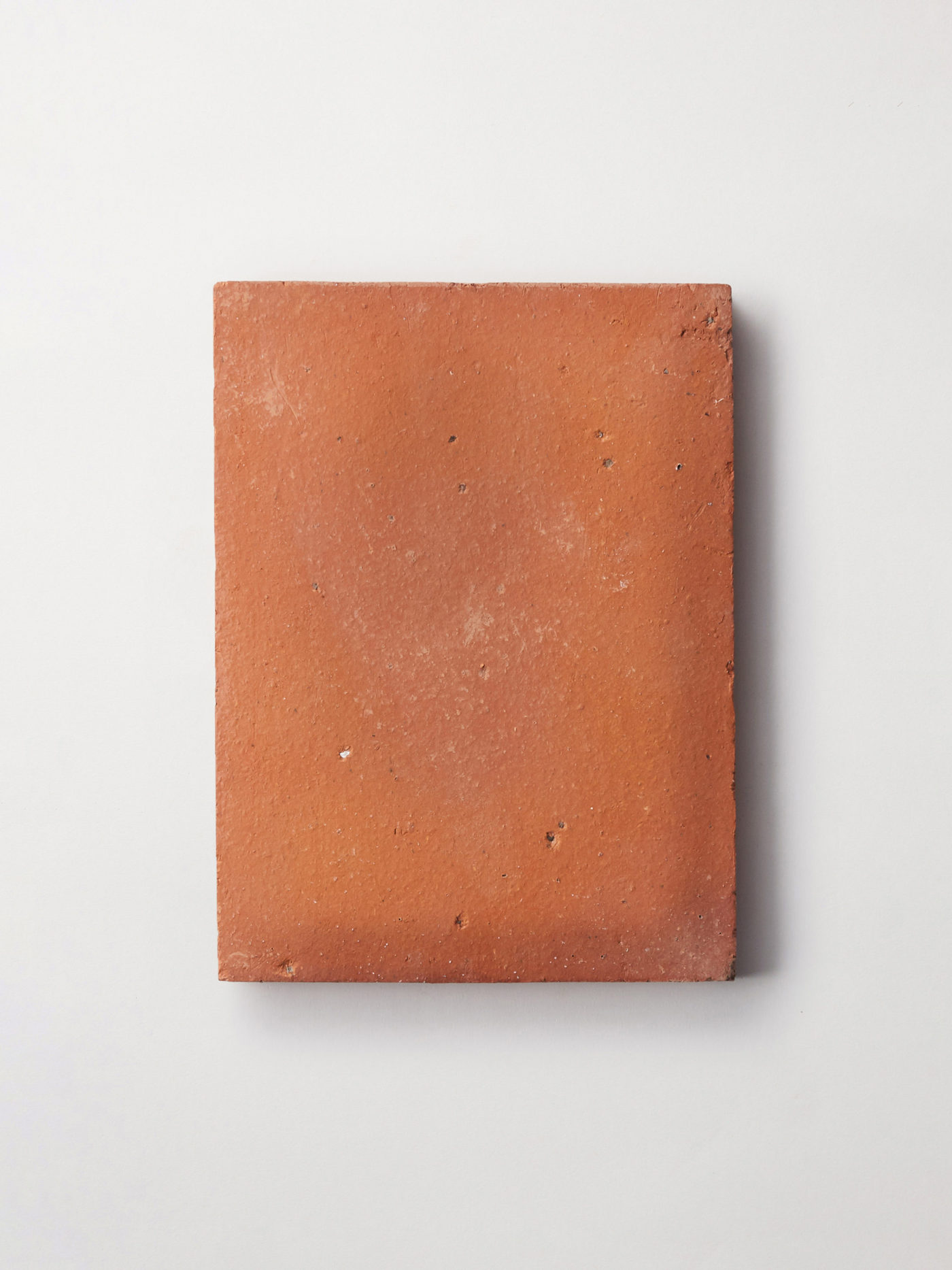 a rectangular red clay tile on a white background.