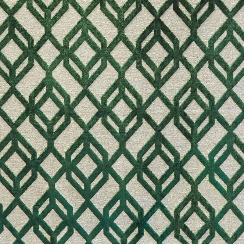 Beige rug with raised darkâ€‘green geometric diamond lattice pattern, repeating across the surface; the rug lies flat, covering a floorâ€‘like surface in soft, even indoor lighting.