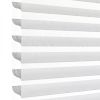 Horizontal zebra (dual-layer) roller blind at the left edge with alternating sheer and opaque stripes, aligned to filter and diffuse bright daylight; close-up, minimal interior against a white background.
