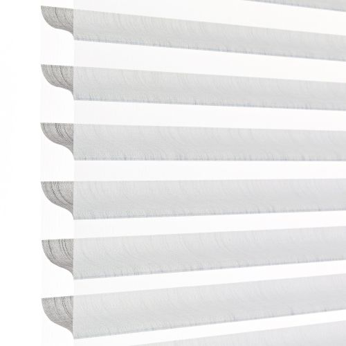 Horizontal zebra (dual-layer) roller blind at the left edge with alternating sheer and opaque stripes, aligned to filter and diffuse bright daylight; close-up, minimal interior against a white background.