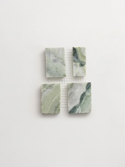 four squares of green marble on a white surface.
