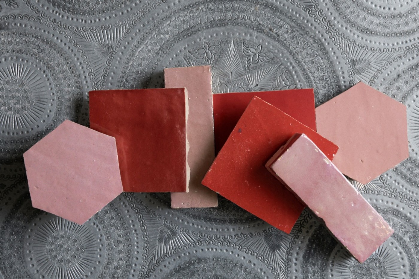 a group of pink and red tiles laid out on a table.