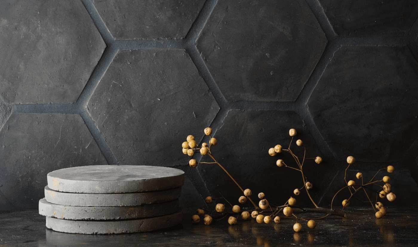 a stack of grey terracotta coasters on a black surface.