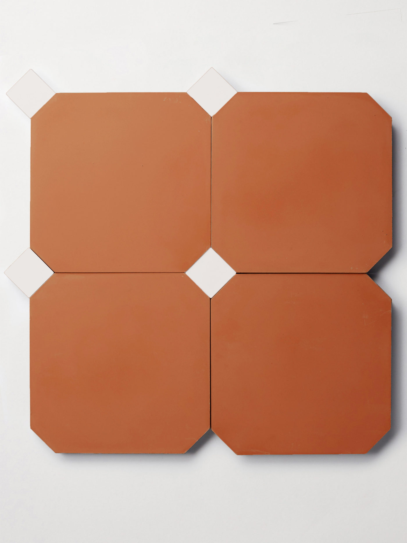 a set of four red octagons and four smaller white square tiles on a white surface.