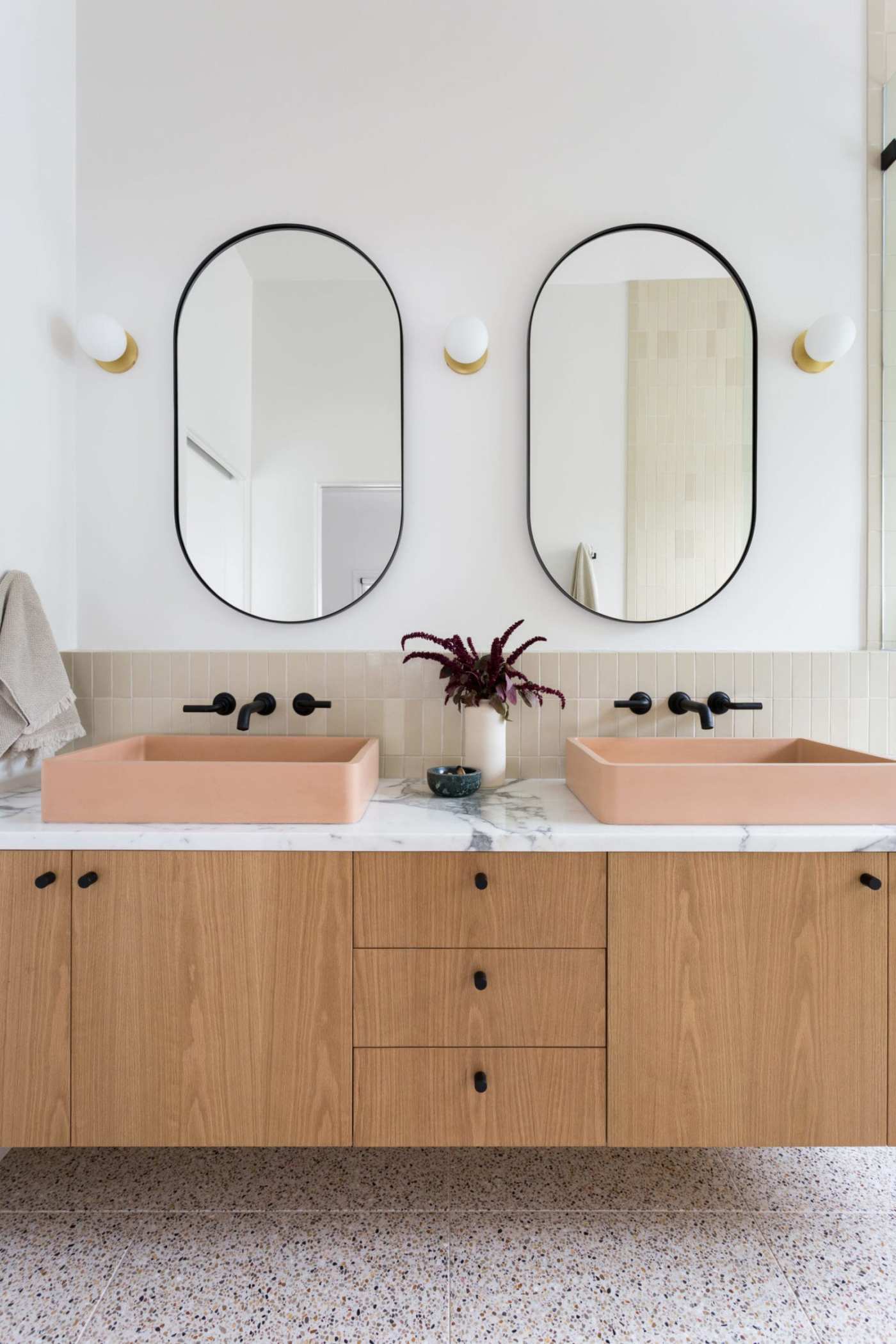 a bathroom with two sinks and two mirrors.