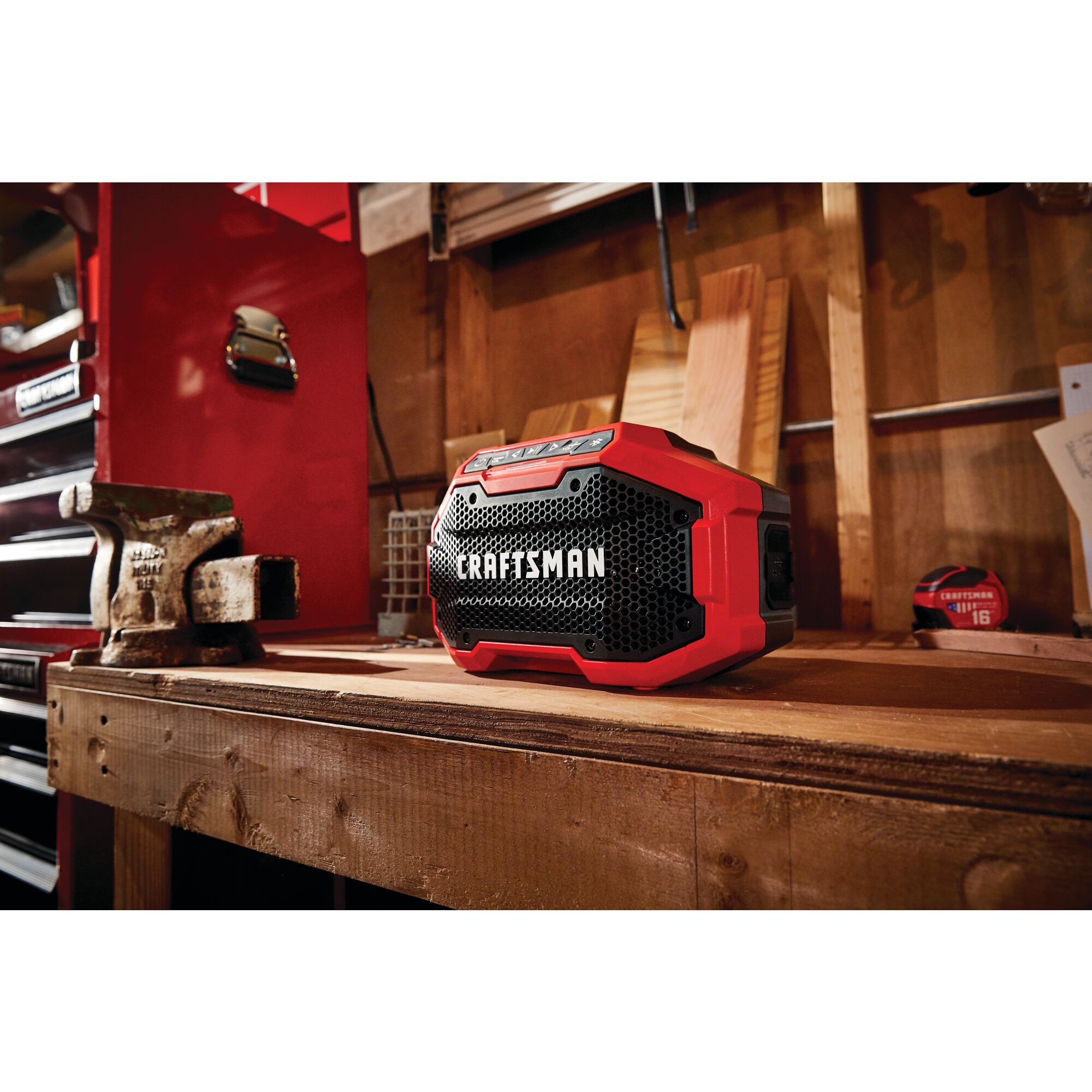 20 volt cordless bluetooth speaker placed on a wooden work station in a work shop.