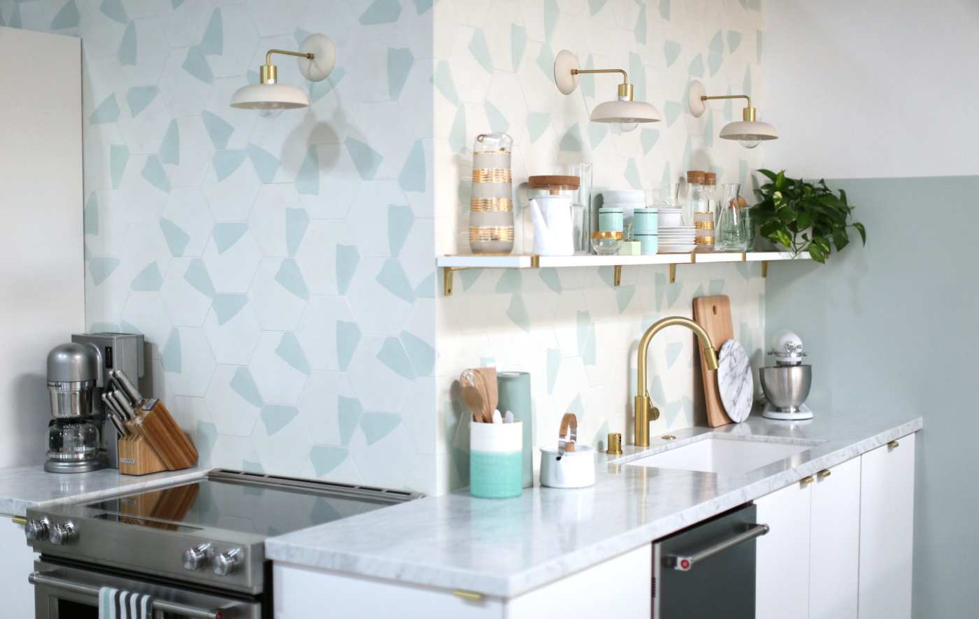 a white kitchen with a blue and white tiled wall.