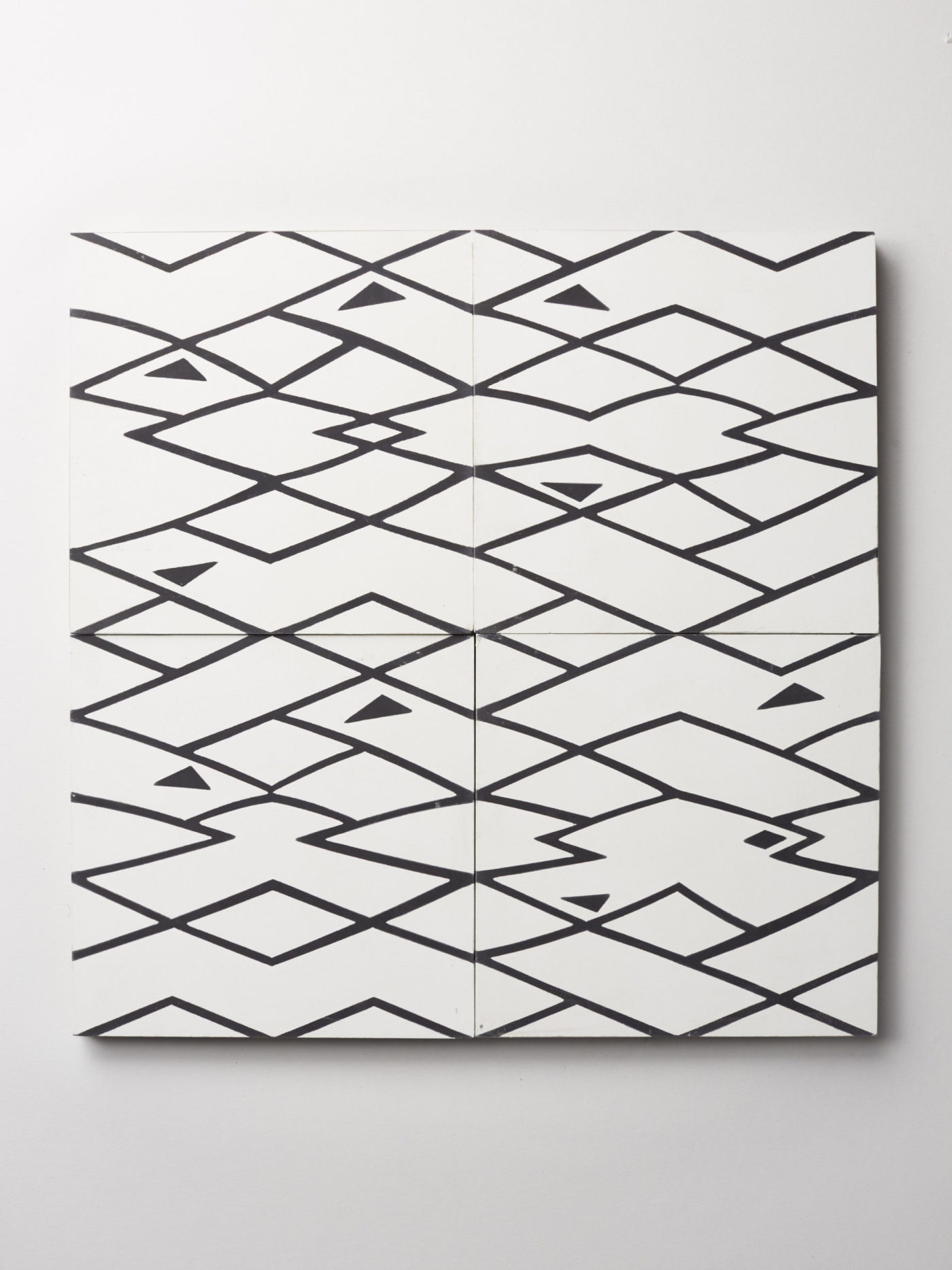 four black and white patterned tiles on a white background.