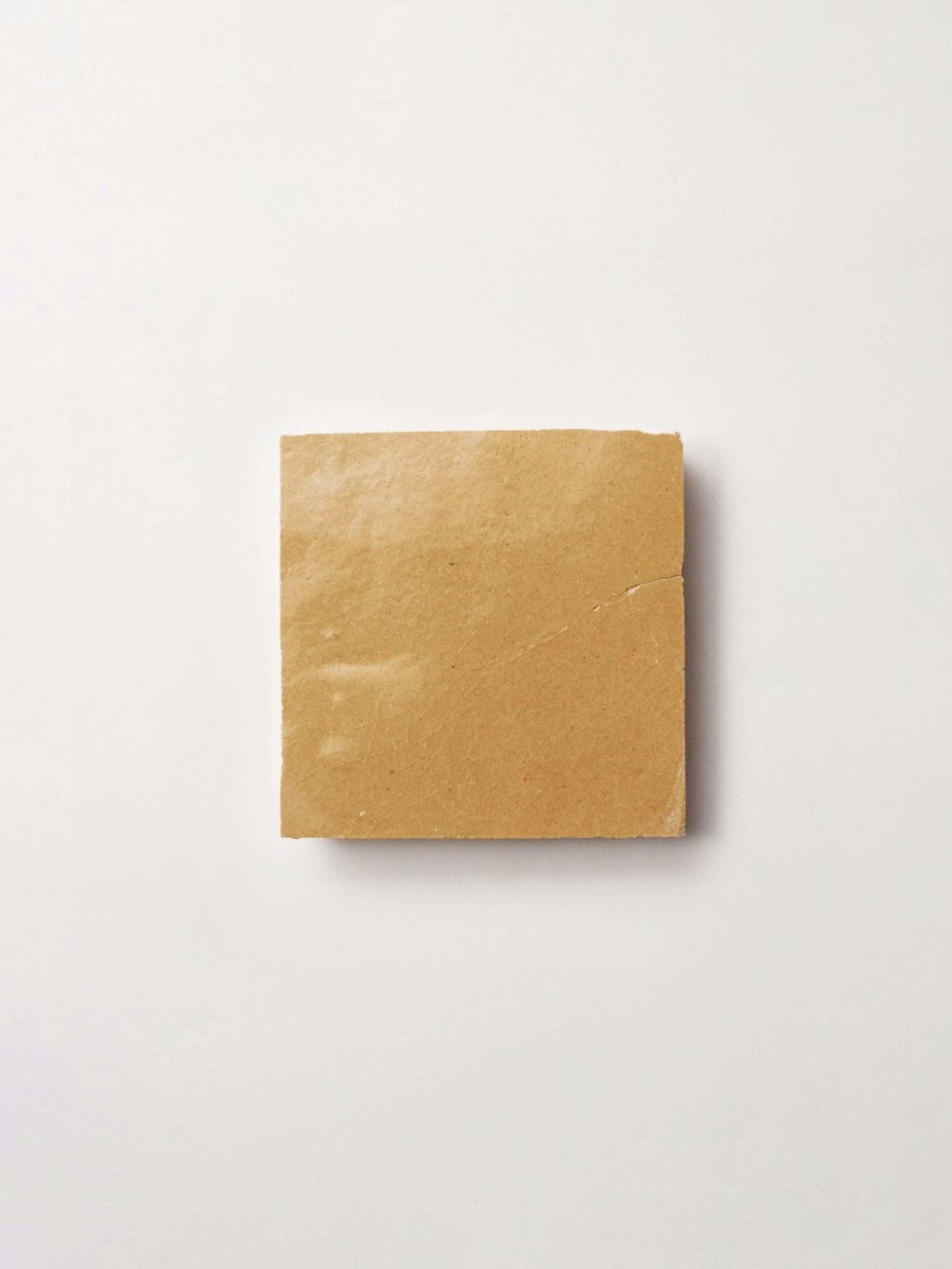 a square brown tile on a white surface.