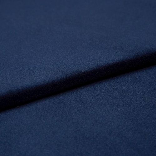 Navy-blue soft fabric, folded into overlapping layers creating a diagonal ridge and subtle shadow, showing a fine, slightly nappered texture; close-up studio view with soft, even lighting.
