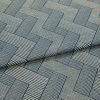 Blue-and-cream woven fabric with interlocking rectangular striped pattern, partially folded and layered, showing raised texture and seam â€” close-up on a flat surface under soft studio lighting.