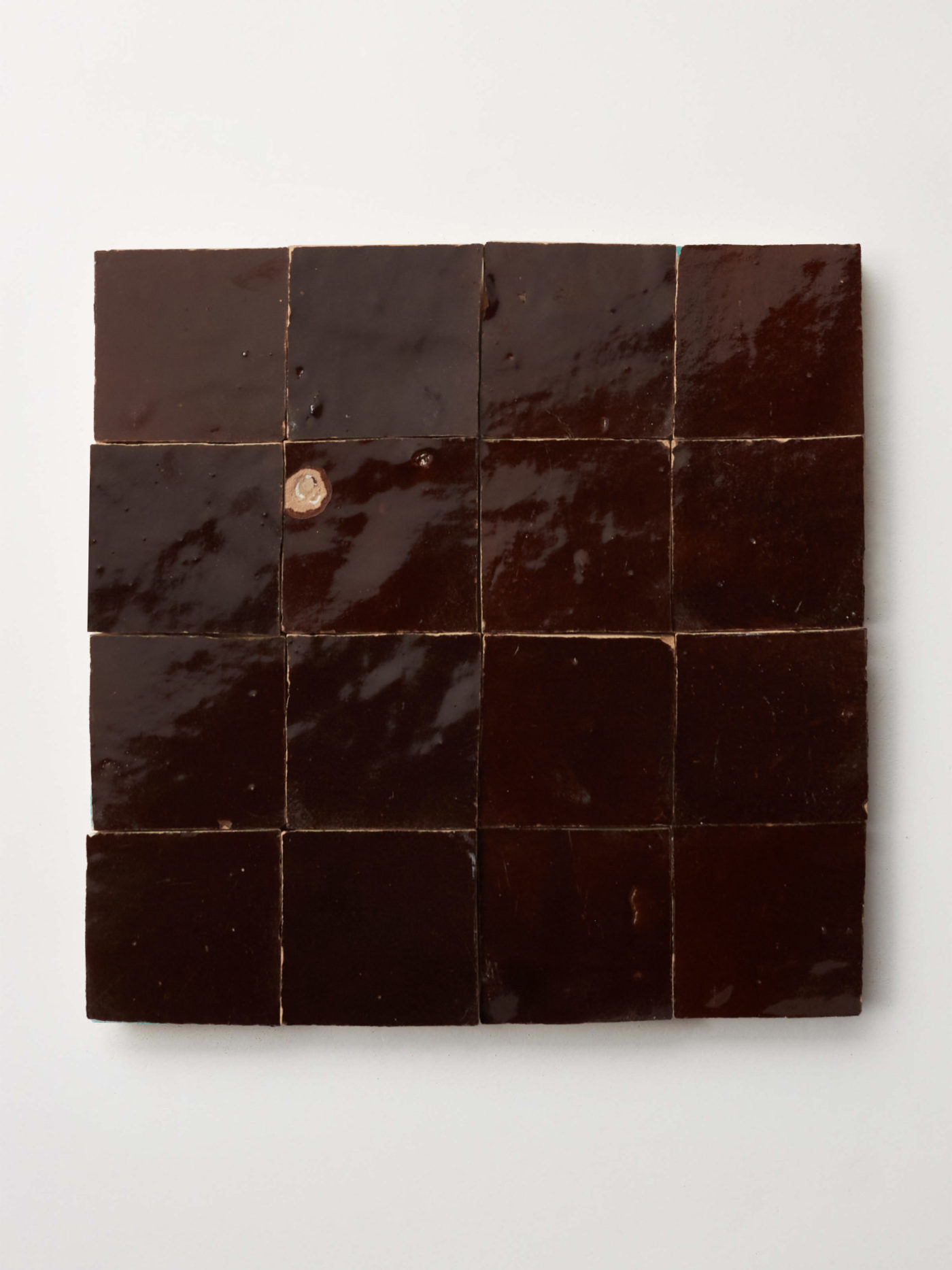 16 square brown tiles on a white surface.