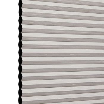 Honeycomb cellular blind, lowered and fully closed with visible hexagonal cell ends and beige horizontal pleats, blocking light; photographed against a plain white studio background.