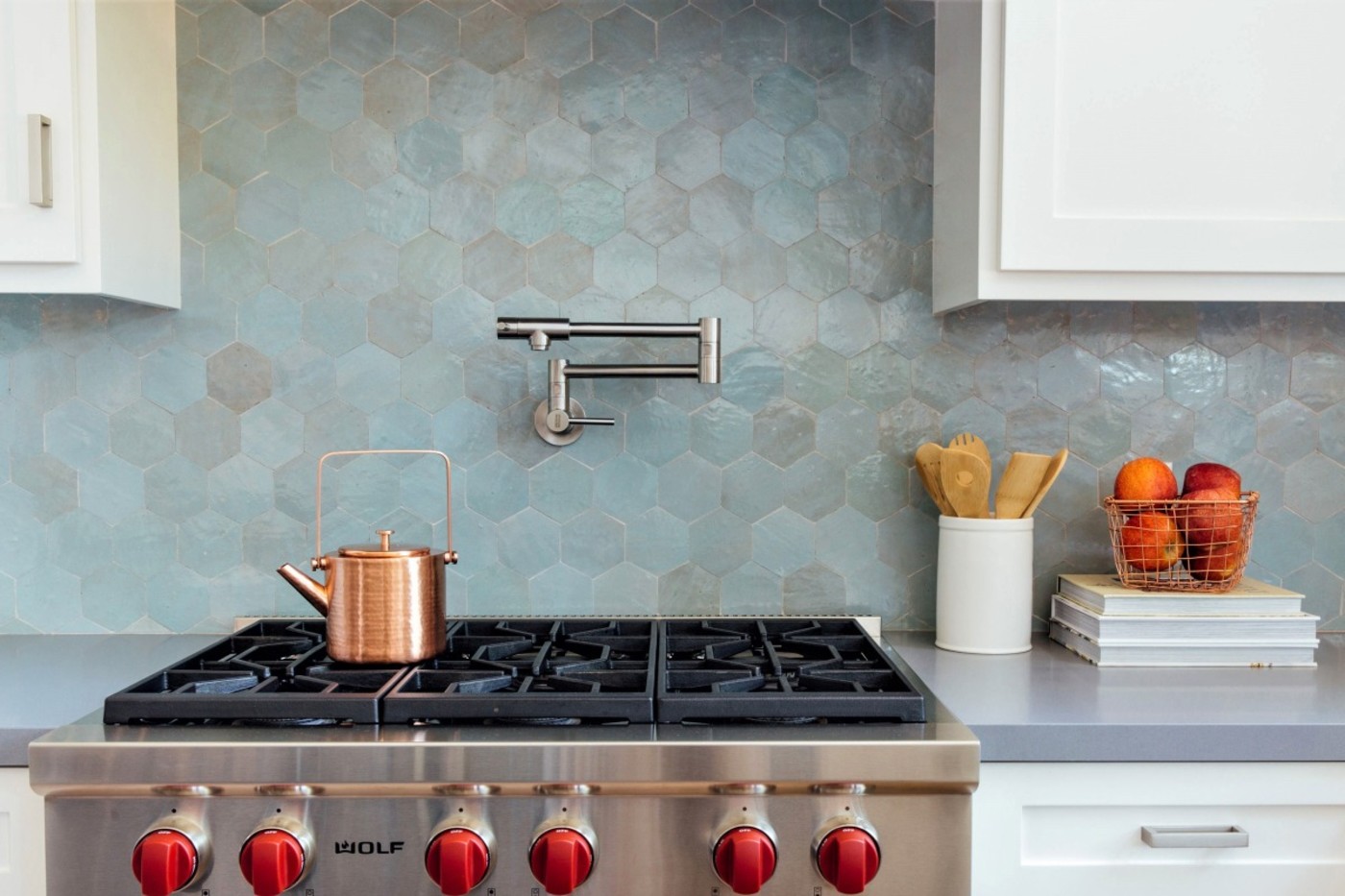 a kitchen with a stove and a blue tile backsplash.