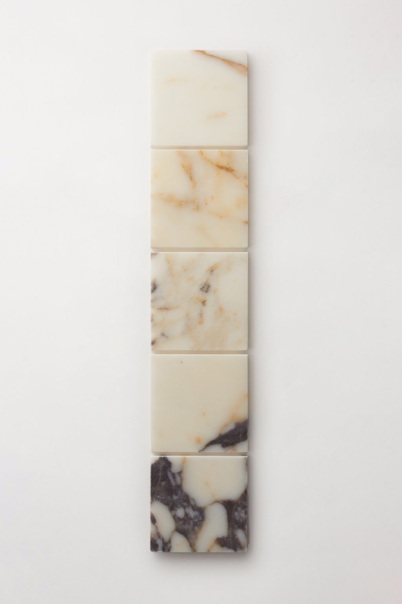 a row of marble tiles on a white surface.