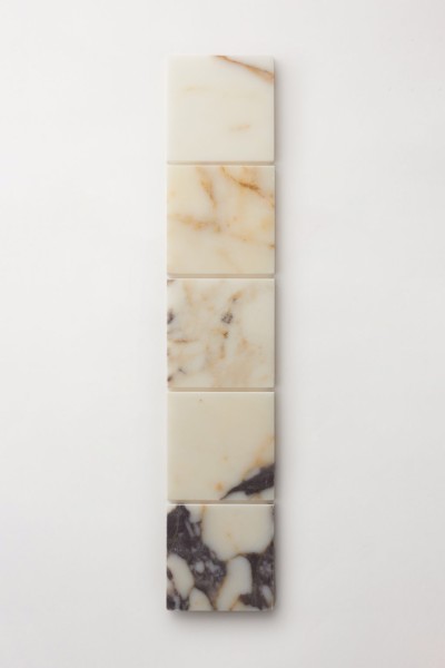 a row of marble soap bars on a white surface.