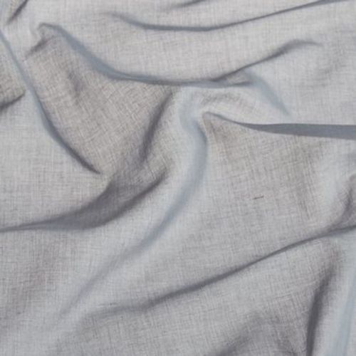 Light-gray woven fabric (linen-like) draped and rumpled into soft folds and creases, lying across a flat surface in diffuse indoor light, showing visible weave texture and subtle shadows.