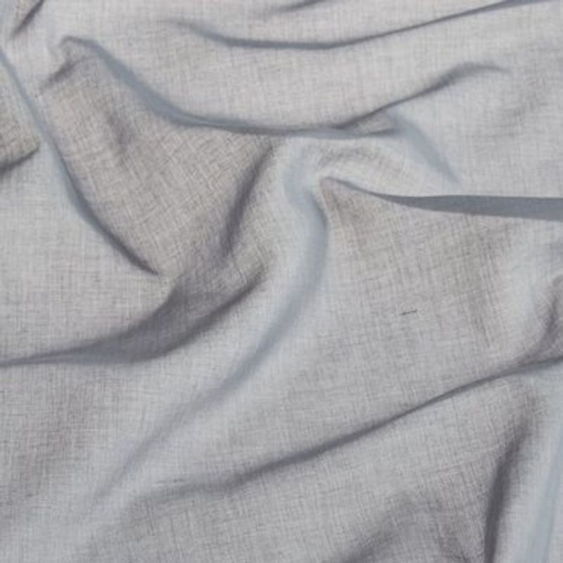 Light-gray woven fabric (linen-like) draped and rumpled into soft folds and creases, lying across a flat surface in diffuse indoor light, showing visible weave texture and subtle shadows.