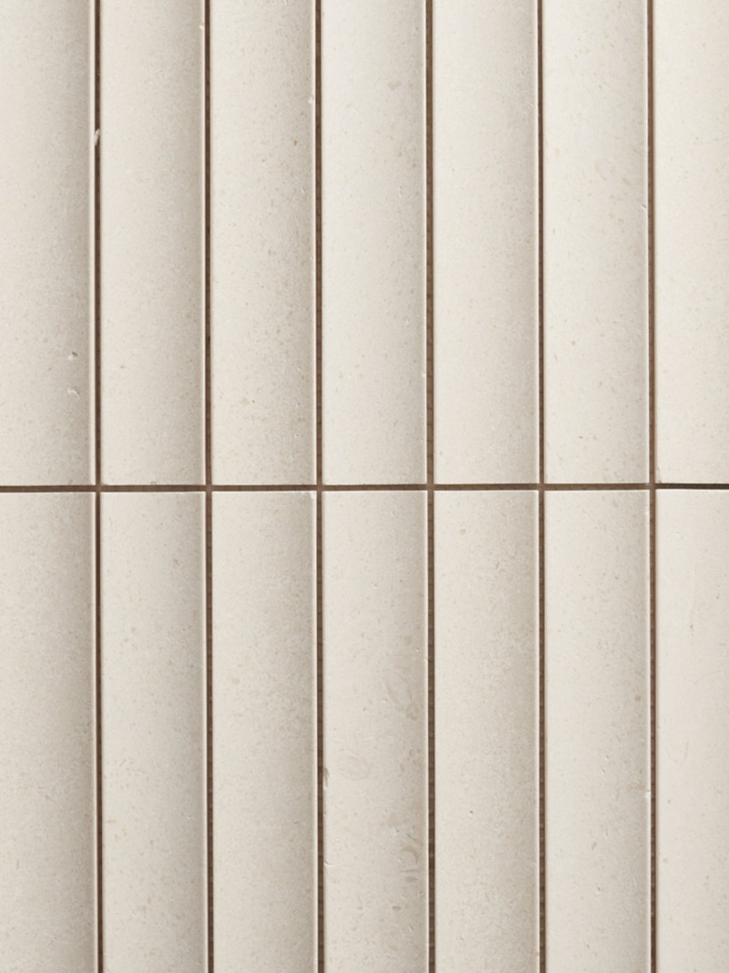 a close up view of a white tiled wall.
