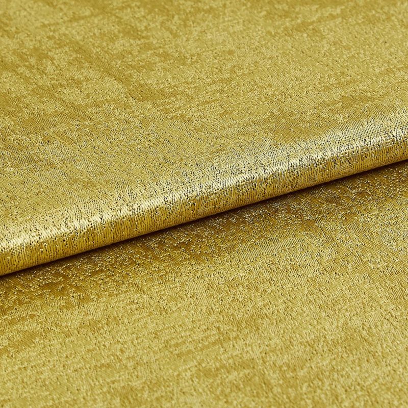 Gold metallic fabric with textured, slightly crushed nap, folded once across the frame; surface reflects light, showing shimmer and fine irregular grain, photographed under even studio lighting on flat backdrop.