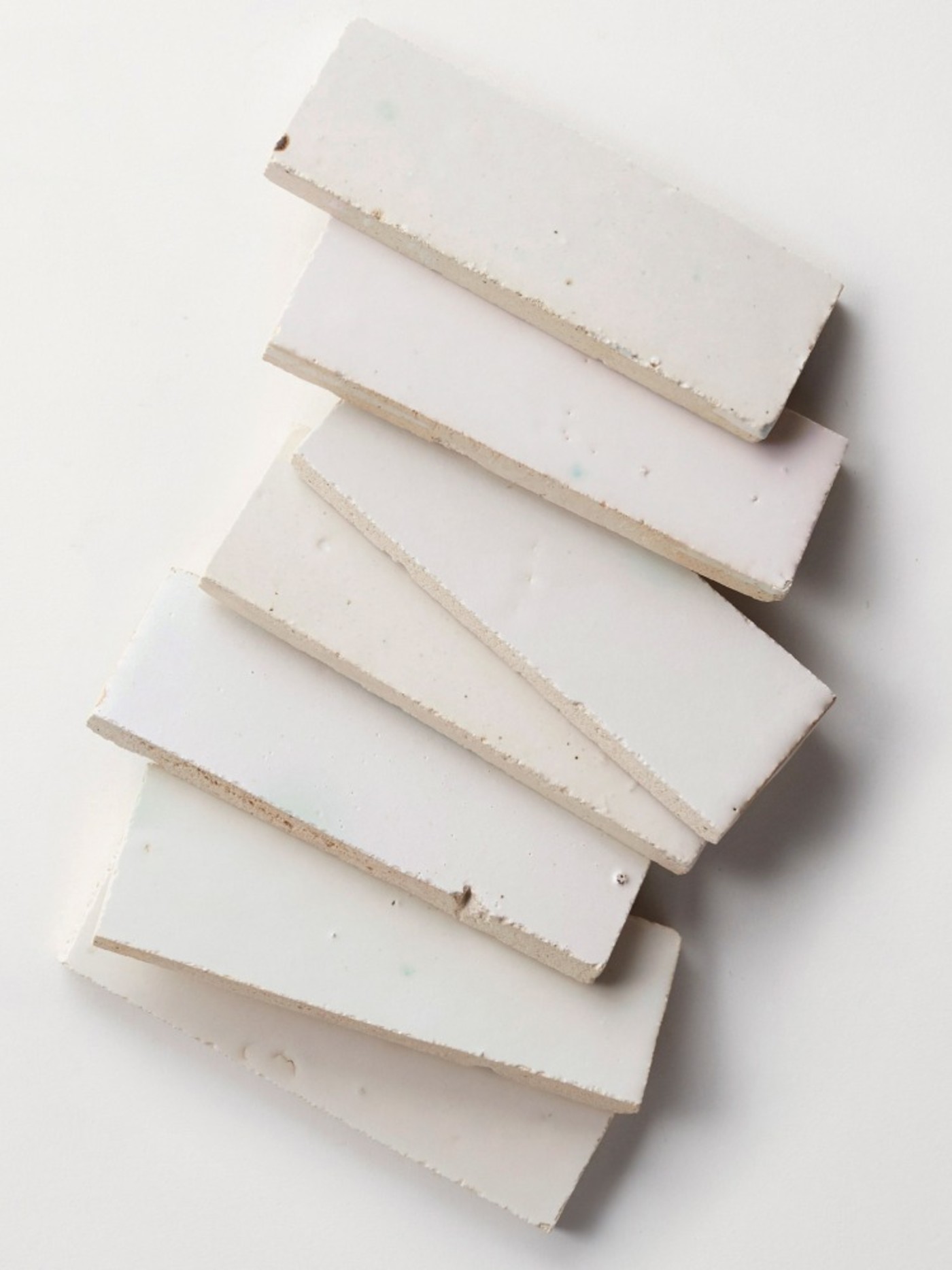 a stack of white rectangle tiles on a white surface.