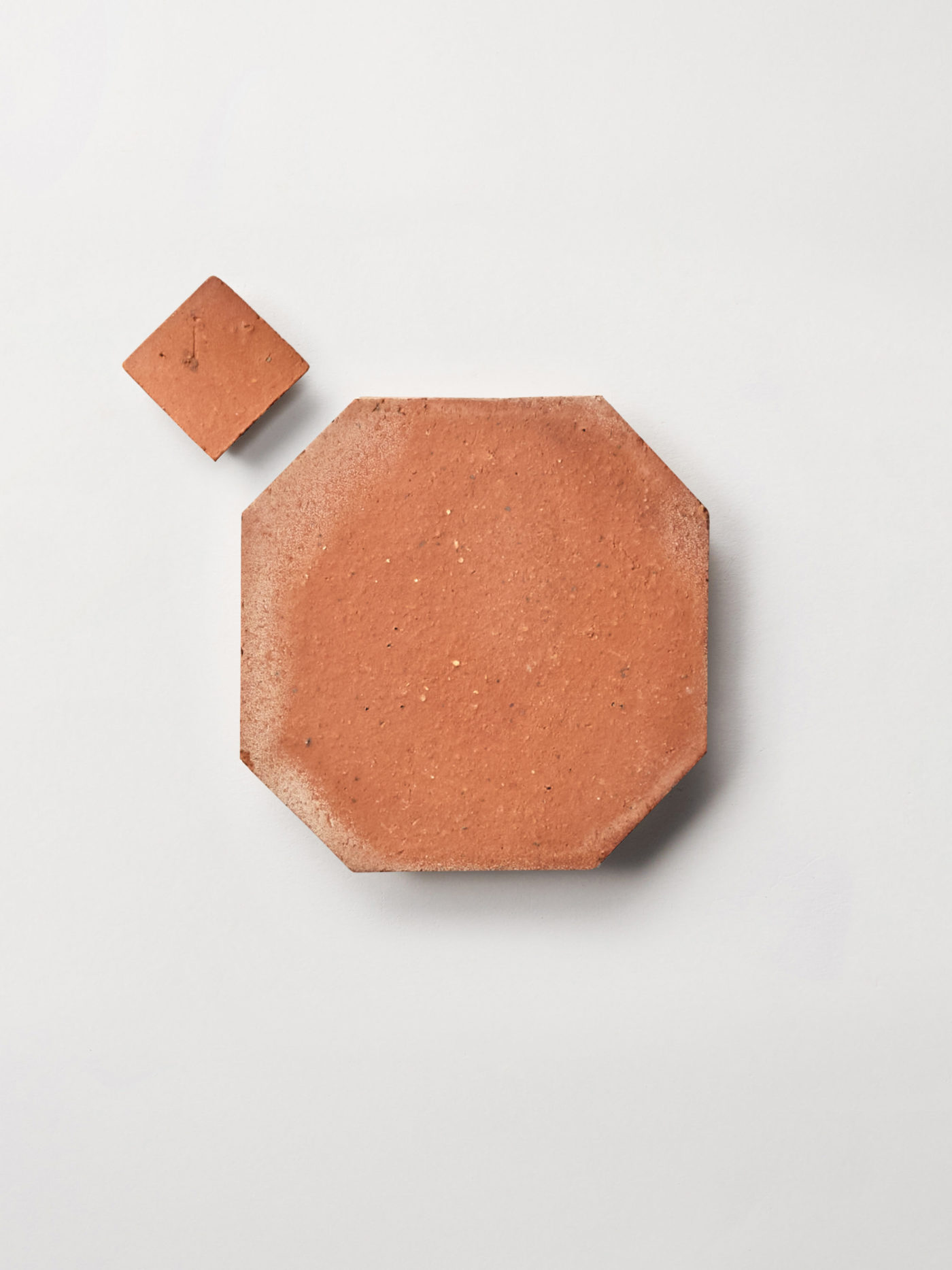 pieces of terracotta tile on a white surface.