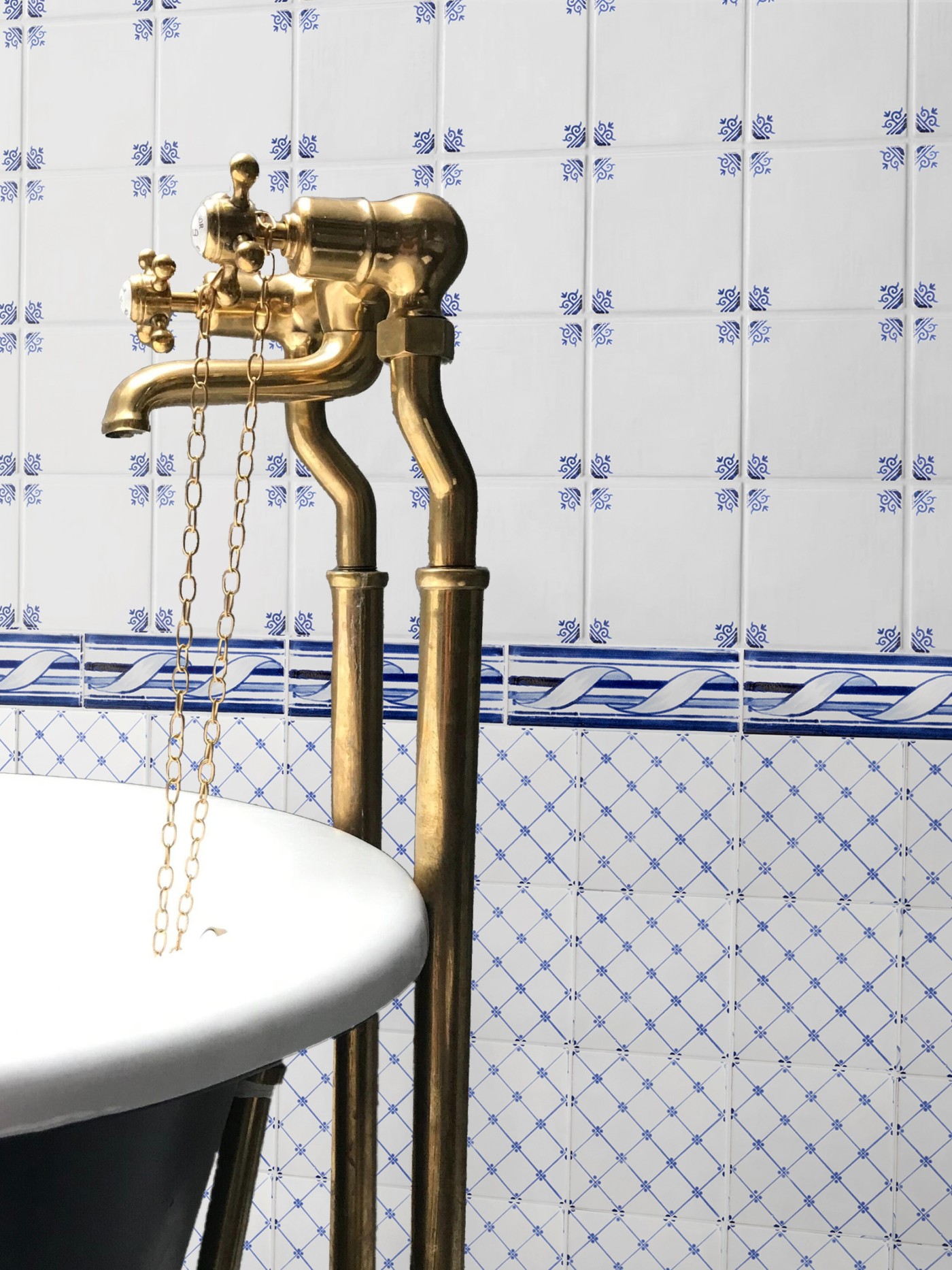 a bathroom with a blue and white tiled wall.