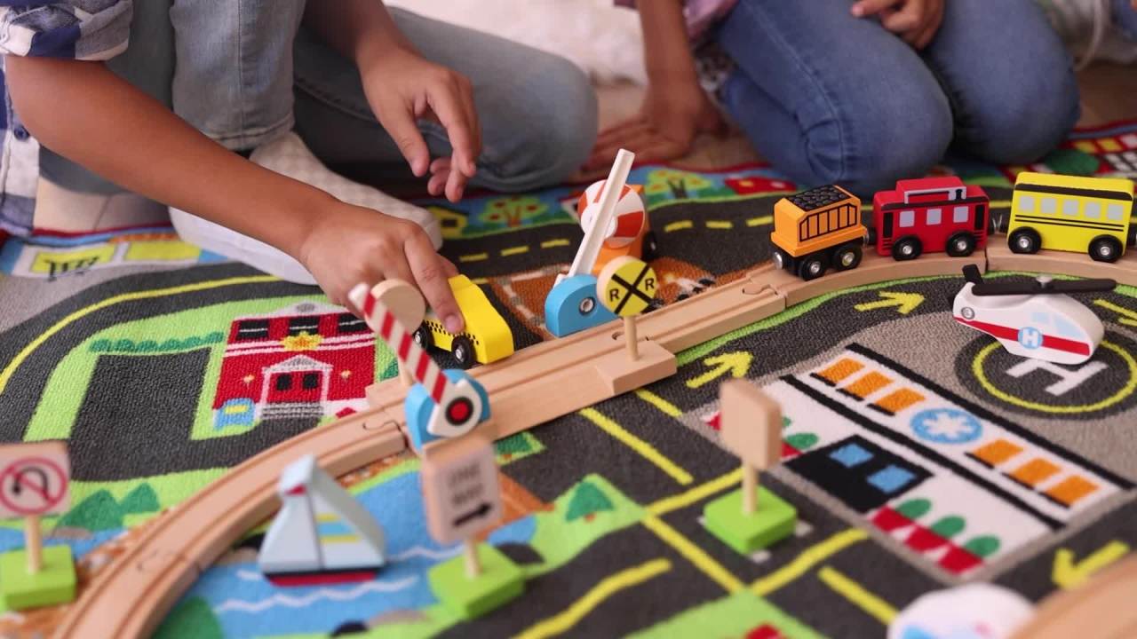 thumbnail video image 2 of Melissa & Doug Deluxe Multi-Vehicle Activity Rug (39.5" x 36.5") - 19 Vehicles, 12 Wooden Signs, Train Tracks, 2 of 10